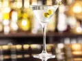 Elegancki gin z wermutem, ozdobiony dwiema oliwkami, czeka na Ciebie przy barze.