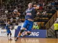 Marek Daćko w skoku do rzutu piłką ręczną. Widownia na trybunach.
