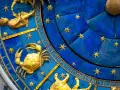 Złoty rak na niebieskiej tarczy zegara astronomicznego. To znak zodiaku Rak, który przypada na okres 15 lipca.