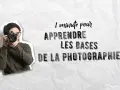 Une personne avec des lunettes tient un appareil photo, prête à capturer le monde. Le texte "1 minute pour apprendre les bases de la photographie" suggère une introduction rapide à cette technique photo.