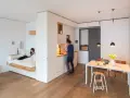Un letto sospeso, una cucina moderna e un tavolo da pranzo creano un ambiente accogliente in queste case piccole bellissime.