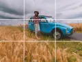 Une femme souriante, chapeau de paille, pose près d'une voiture bleue vintage au milieu d'un champ de blé doré. Photos prises sur le vif.