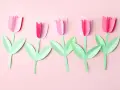 Fünf rosa Papier-Tulpen mit grünen Blättern, ein einfaches Bastelprojekt für Kinder.