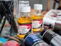 Pinceaux, flacons d'huile médium Daler Rowney et tubes de peinture à l'huile. La question "peut on mettre du gesso sur peinture à l'huile" plane sur cet atelier.