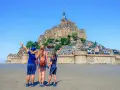 Famille en visite à Mont Saint-Michel, émerveillée par le château perché sur son îlot rocheux.