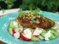 En gyllene kyckling kiev toppas med citronzest och persilja, serverad på en bädd av krispig sallad med rädisor och krämig dressing.