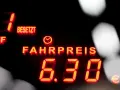 Rotes Leuchtdisplay zeigt "FAHRPREIS 6.30 €". Der taxameter preis ist klar ersichtlich.