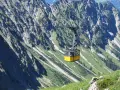 Gelbe Seilbahn schwebt über steile Hänge, ideal für eine Nebelhorn Wanderung.