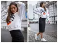 Stylowy crewneck z napisem Chicago Bears i grafiką, zestawiony z czarną spódnicą ołówkową i białymi sneakersami.