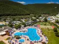 Wakacje na **camping Oliva** to baseny, korty tenisowe i mnóstwo zieleni pod górą.