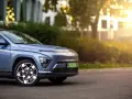 Niebieski Hyundai Kona Electric zaparkowany na ulicy, z widocznym przodem i kołem.
