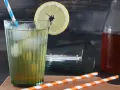 Erfrischender Eistee mit Zitrone, Eis und einem blauen Strohhalm. Perfekt, wenn du Eistee Sirup selber machen möchtest.