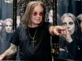 Ozzy Osbourne, geboren 1948, sitzt auf einem Thron und zeigt mit dem Finger. Im Hintergrund sind Bilder von ihm zu sehen.