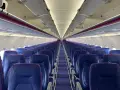 Puste fioletowe siedzenia w samolocie Wizz Air.