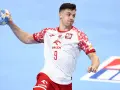 Szymon Sićko w akcji, rzuca piłkę ręczną.
