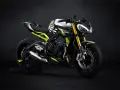 Agresywny Triumph Street Triple w biało-czarnej kolorystyce z neonowo-żółtymi akcentami, zdominowany przez złote lagi i sportowy wygląd.