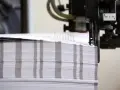 Stos papieru czeka na wykończenie. Powstają tu wydruki fine art, które zachwycą jakością.