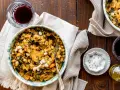 Un piatto di fagioli e verdure, un classico esempio di cose tipiche toscane, accompagnato da vino rosso e olio.