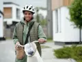 Junges Mädchen mit Fahrrad und Helm, bereit für ihre ersten jobs ab 14. Sie lächelt optimistisch in die Kamera.