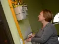 Kobieta przygląda się licznikom gazu. Dowiedz się, co ile wymienia się licznik gazu, by uniknąć problemów.