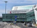 Nowoczesny budynek Lotniska Chopina w Warszawie. Droga prowadzi do terminalu, gdzie zaczyna się podróż z Warszawy Centralnej do lotniska Chopina.