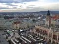 Widok na Rynek Główny w Krakowie z dominującą wieżą Mariacką. W dole kramy jarmarku, Sukiennice i kościółek.