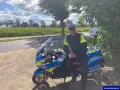 Policjant w pełnym umundurowaniu siedzi na swoim policyjnym motocyklu, gotowy do służby.
