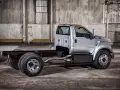 Srebrny Ford F750 bez zabudowy, gotowy do pracy. Potężna rama i podwójne tylne koła.