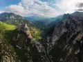 Majestätische Berge der Picos de Europa, grüne Täler und eine Straße, die sich durch die zerklüftete Landschaft schlängelt.