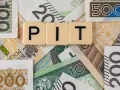Litery "PIT" na tle polskich banknotów o różnych nominałach.