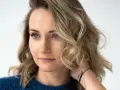 Zuzanna Irena Grabowska z burzą blond włosów i niebieskimi oczami, w granatowym swetrze.