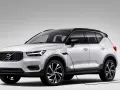 Biały Volvo XC40 Recharge plug-in hybrid podłączony do ładowarki.