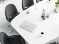 Tavolo da riunione con laptop, bicchieri d'acqua, caffè e un vaso di fiori. Ideale per un ingegnere gestionale lavoro.