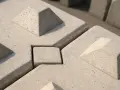 Betonowe pustaki zalewowe z wypustkami i wgłębieniami, tworzące stabilną, geometryczną powierzchnię.