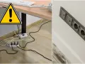 Ostrzeżenie przed bałaganem kabli pod biurkiem. Po prawej stronie widać estetyczną, nowoczesną instalację elektryczną.
