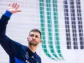 Michał Przybylak wita kibiców, unosząc dłoń.