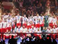 Polscy siatkarze świętują sukces na mistrzostwach świata w siatkówce 2026, z medalami na szyjach i flagą narodową w tle.