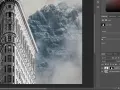 Edytowany w lut photoshop obraz przedstawia budynek w kształcie klina na tle mglistych gór.