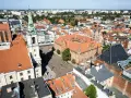 Widok na rynek i zabytkowe budynki Torunia, jednego z obiektów UNESCO w Polsce. Widać Ratusz Staromiejski i wieżę kościoła.