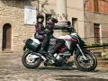 Para jadąca na sportowym motocyklu Ducati przez urokliwe, brukowane uliczki.