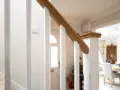 Barandilla de escalera blanca con pasamanos de madera, ideal para saber como modernizar una barandilla de madera.