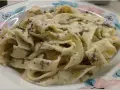 Pappardelle z kremowym sosem z mascarpone i aromatyczną pastą truflową, podane na talerzu z kwiatowym wzorem.