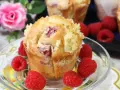 Pyszne muffinki z malinami, posypane kruszonką, otoczone świeżymi malinami.