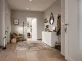 Stilvoller Flur gestalten: Grauer Sessel, Teppich, weiße Kommode mit Spiegel und Garderobe schaffen eine einladende Atmosphäre.