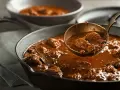 Gęsty, aromatyczny gulasz wołowy w żeliwnej patelni, gotowy do podania. Idealny przykład, jak zagęścić gulasz, by uzyskać aksamitną konsystencję.