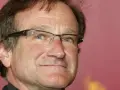 Primo piano di Robin Williams con occhiali, un uomo che ha portato gioia a molti, anche se il suo figlio morto non ha potuto vederlo.