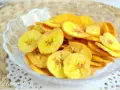 Crujientes rodajas de plátano frito doradas, servidas en un cuenco de cristal. Un delicioso snack casero.