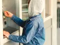 Jugendlicher mit Kapuze und Jeansjacke am Geldautomaten. Ein Beispiel für mögliche Verhaltensauffälligkeiten, die auf Kleptomanie bei Kindern hindeuten könnten.