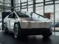 Tesla Cybertruck w salonie Tesli, z widokiem na ulicę przez okno.