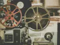 Stare klisze filmowe i projektor, gotowe do odtworzenia historii pełnej emocji i dramatów.
